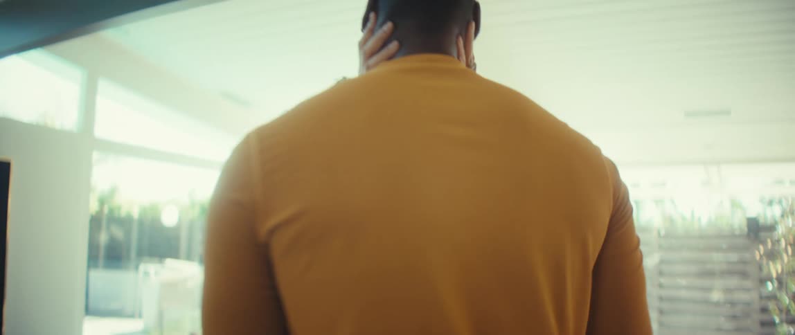 A smiling young couple shares an intimate and romantic slow dance in their bright, modern home