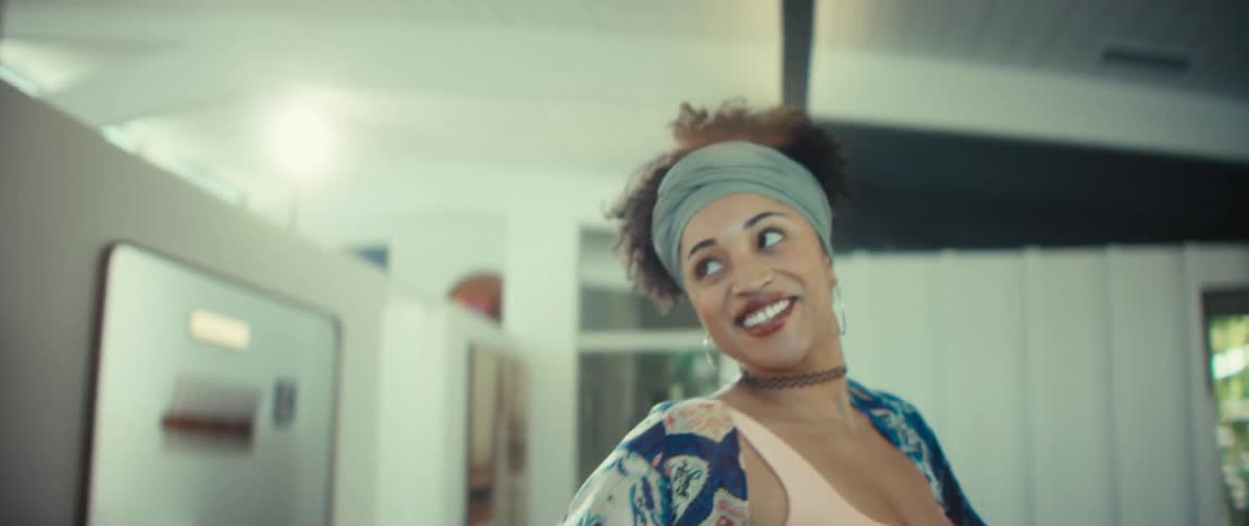 A beautiful and happy young couple slow dances together in their sun-filled modern home
