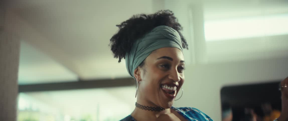 A stylish young Black woman with a beautiful smile dances with her partner in slow motion, ending in a passionate kiss