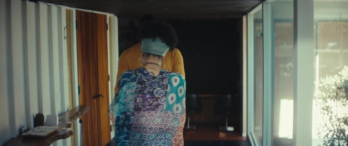 A stylish young couple shares an intimate moment, talking and slow dancing together in their modern home