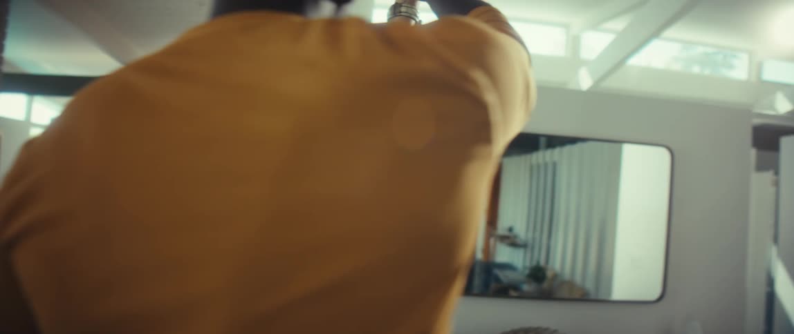 A loving African American couple smiles and shares an intimate slow dance in their bright, modern home