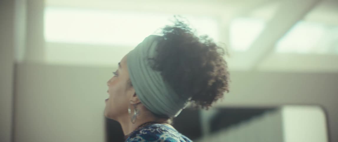 A romantic couple smiles and dances together in slow motion in their bright, sun-drenched home