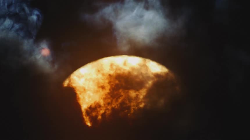 An ominous time-lapse captures the fiery sun rising behind a curtain of dark, swirling clouds