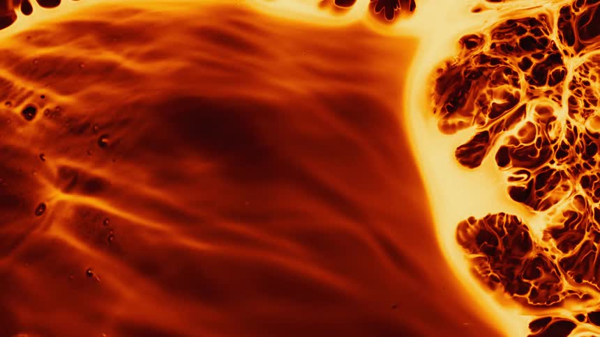 A fiery orange and yellow liquid flows and transforms, creating mesmerizing organic patterns and textures