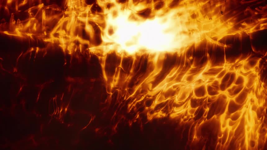 An abstract close-up of a fiery, molten substance slowly morphing and glowing with intense heat