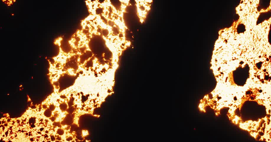 Abstract fire effect burns through a black surface, slowly revealing glowing embers