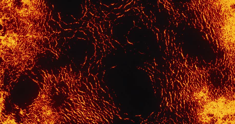 A fiery, glowing, lava-like texture slowly spreads across a dark surface, creating an intense abstract background