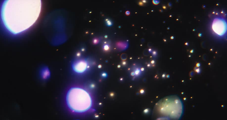 Magical purple and blue bokeh lights create a cosmic galaxy effect on a black background