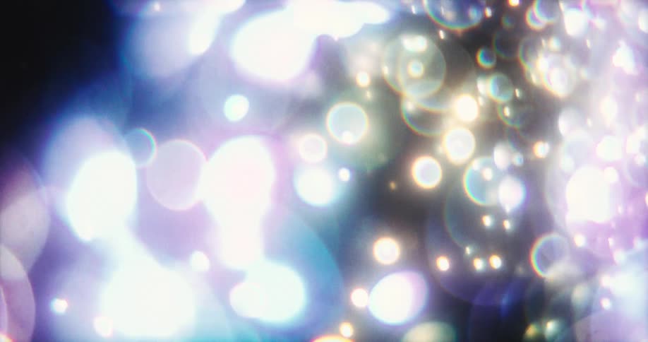 Floating bubbles of vibrant purple and blue light create a magical bokeh effect against a black background