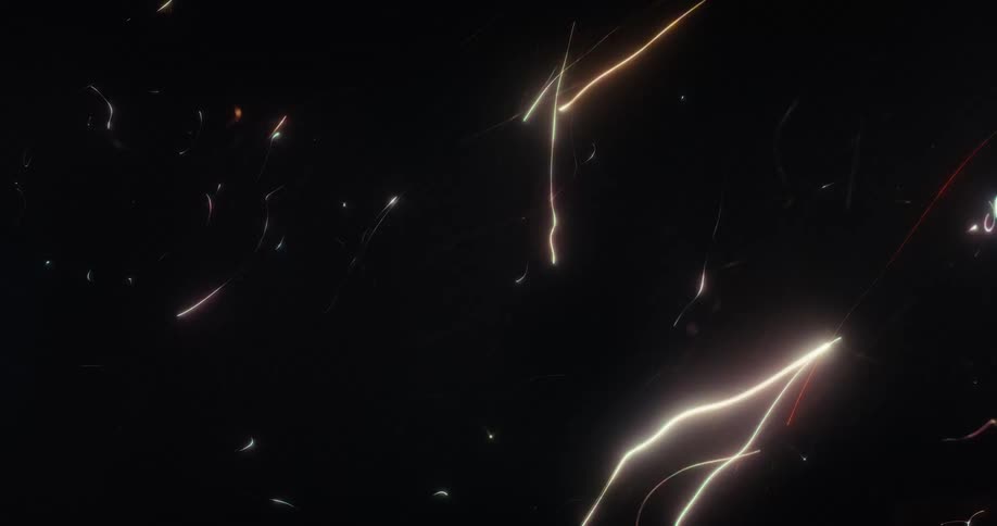 Dynamic animation of glowing, multi-colored light trails and sparks flying through the dark