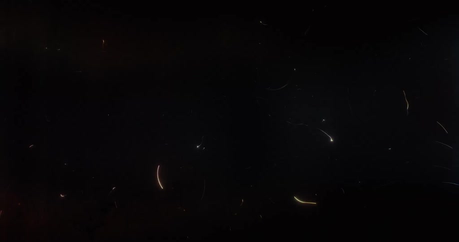 Abstract colorful light streaks and particles animate and dance across a dark background