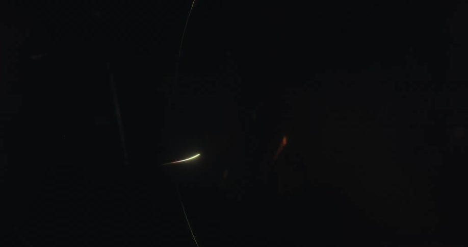 Abstract, glowing, multi-colored light trails swirl and streak across a dark screen