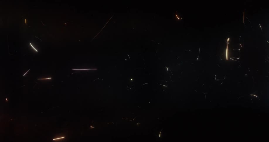 A flurry of multicolored glowing particles and sparks dances chaotically against a dark background