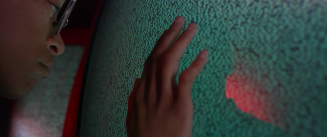 A person puts their hand against a flickering screen