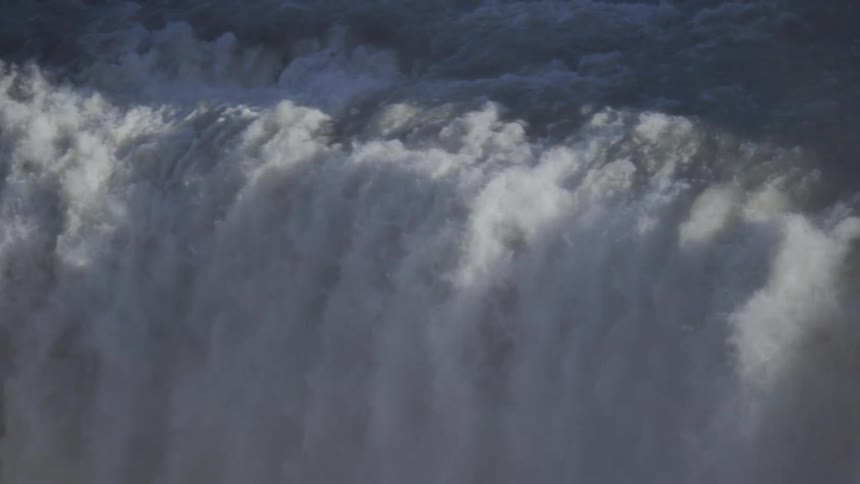 A mesmerizing close-up of a massive waterfall churning and cascading down in dramatic slow motion