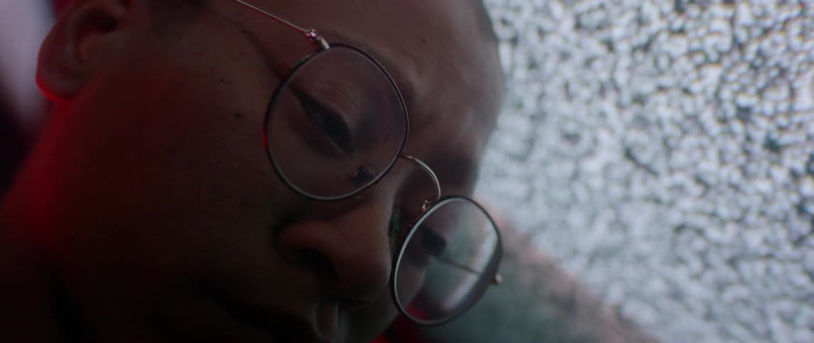 A person looks down in front of a static filled television screen