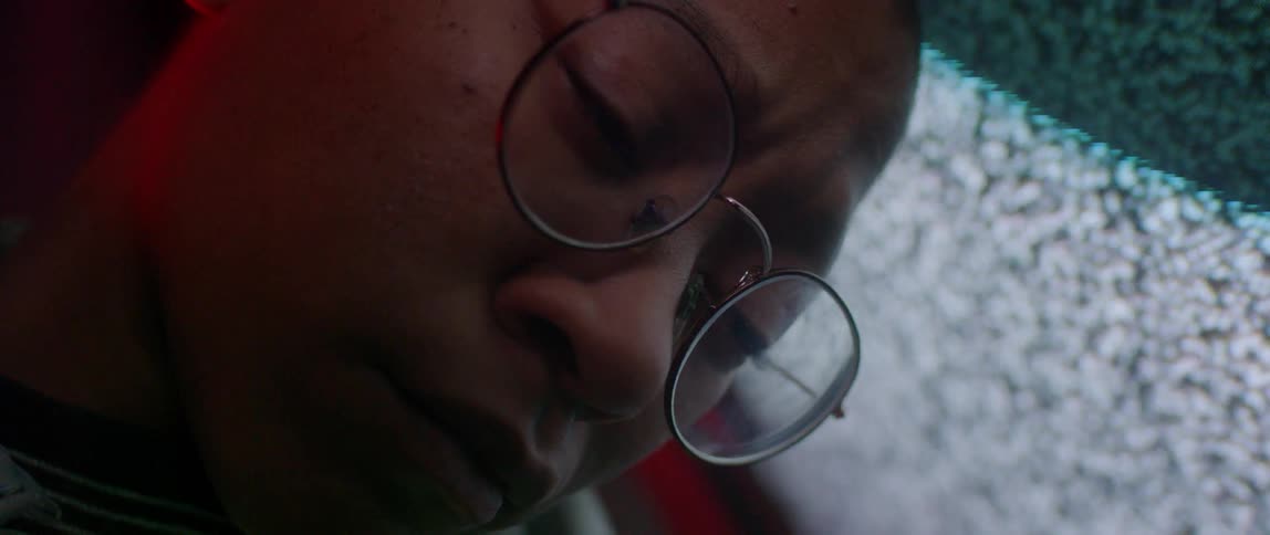 A person leans sleeping against a flickering television