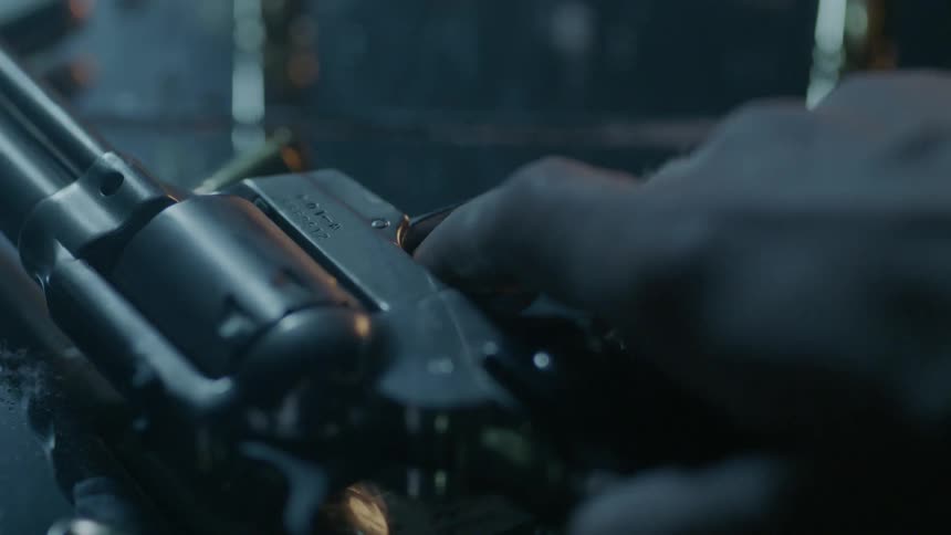 Person grabs a gun off a tabletop