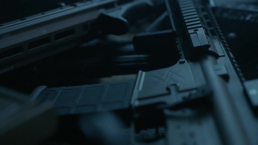 An array of assault rifles sits on top of the table