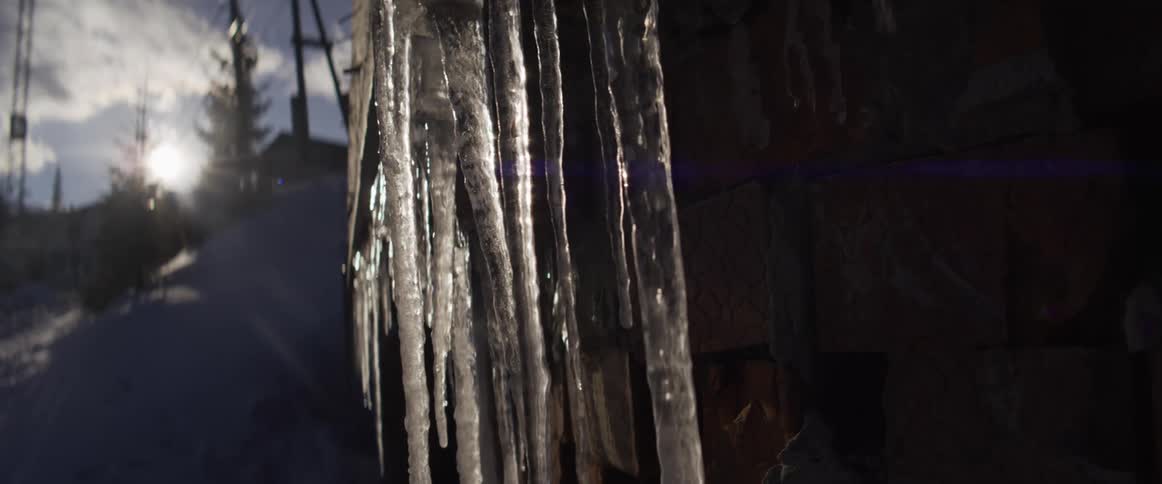 Glistening icicles catch the winter sunlight in a stunning slow-motion close-up shot