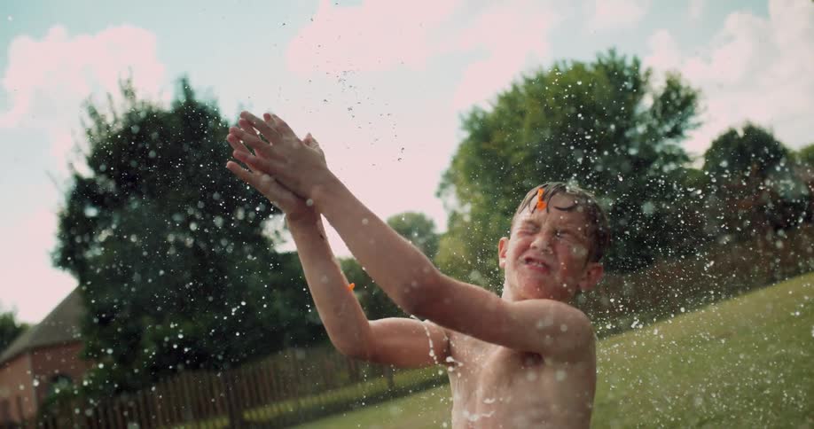 A child tries to catch a water balloon