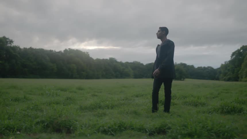 Man standing in a field on a cloudy day