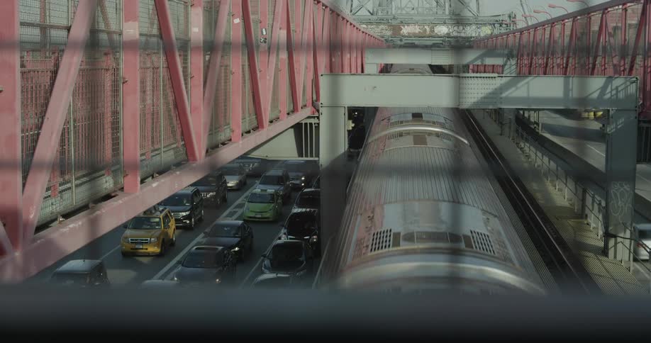 A train moves near a road with traffic slowing