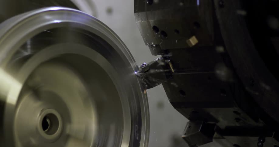 A machine grinds a silver part