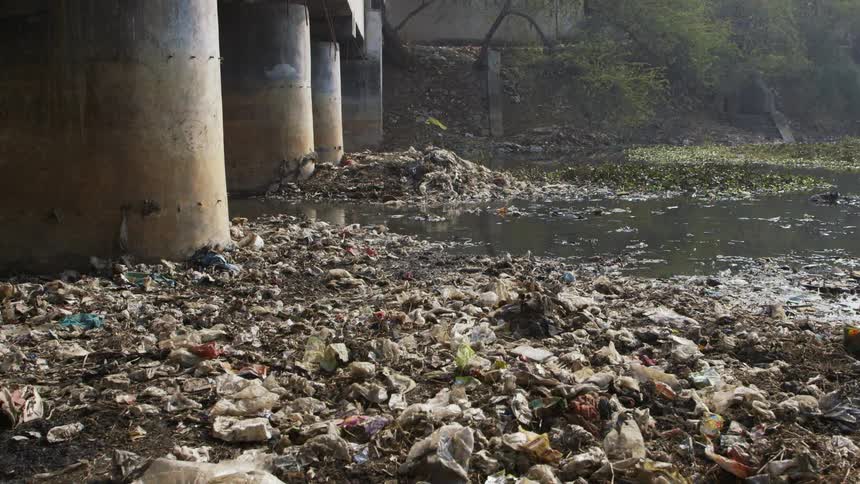 Piles of wet garbage lying near a bridge