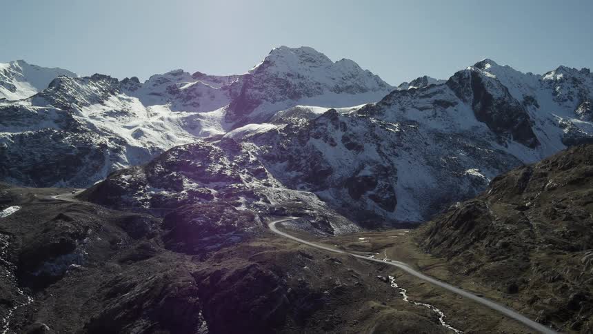 A long, narrow road winds up into a mountain range