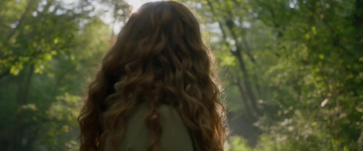 Woman looks around forest