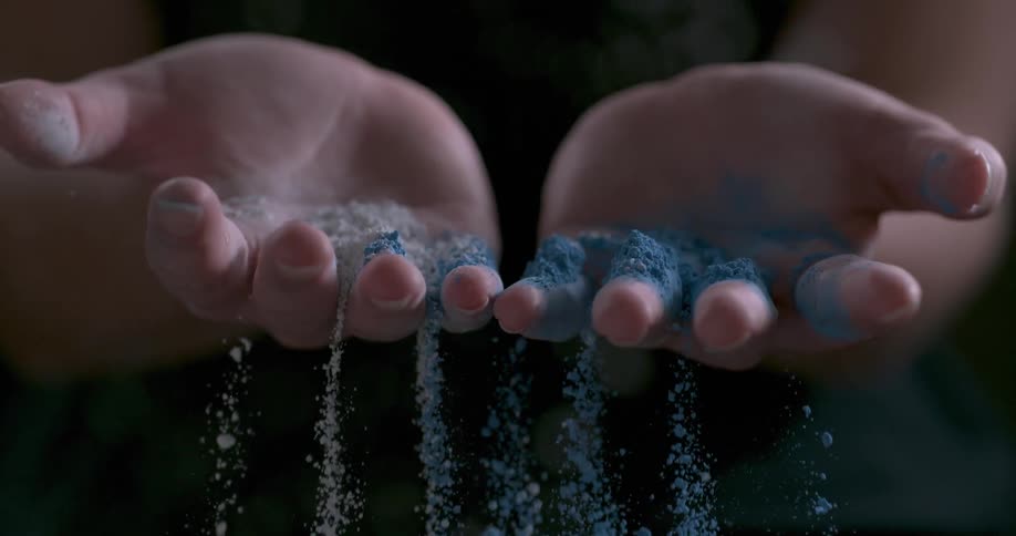 A pair of hands opens and lets sand slip between its fingers