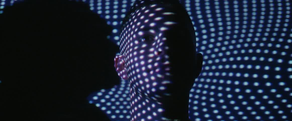 A man has dots of light all over his face