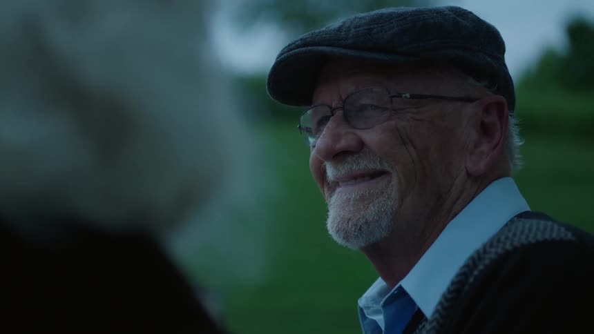 Elderly man and woman smile outside