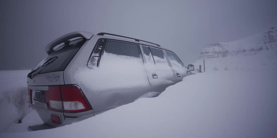 Time-lapse of an SUV getting buried under heavy snowfall during a winter blizzard