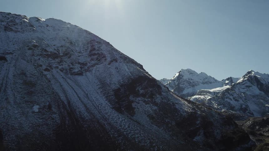Sun shines over snow covered mountains