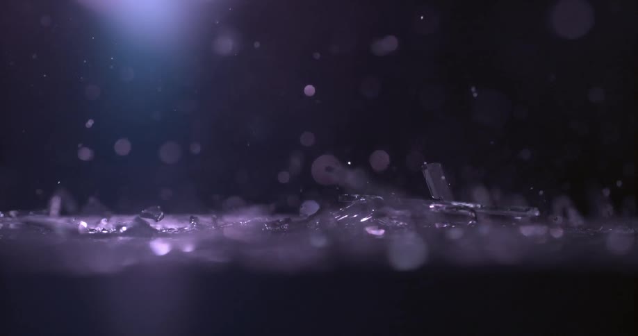 A sheet of glass falls to the ground and shatters