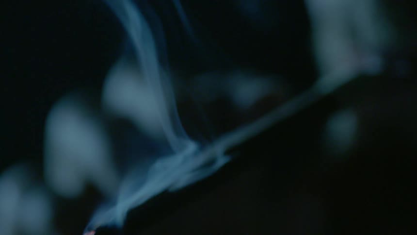 A man lights a cigarette and takes a big drag