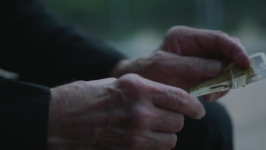 Elderly hands hold an old photograph