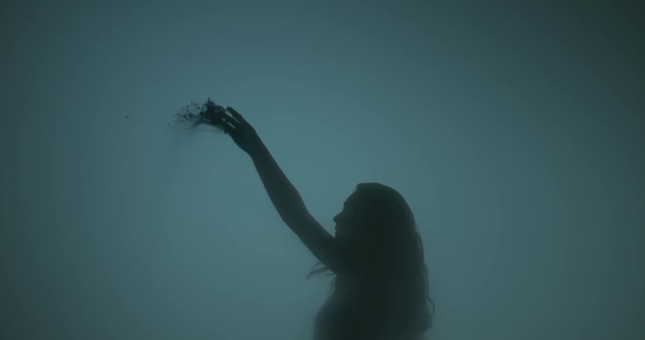 A woman tosses dirt overhead
