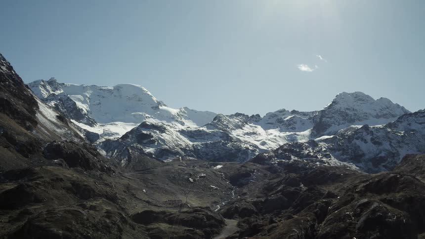 The mountain is tall and covered with snow at the top