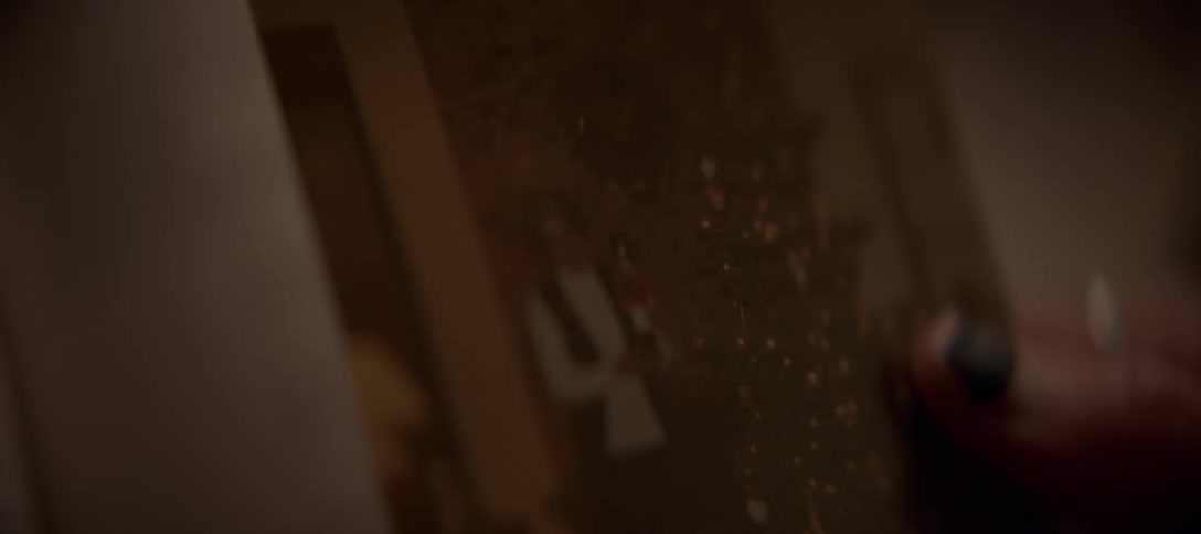 A close-up view of a hand holding a vintage photograph of a woman with a nutcracker next to a Christmas tree
