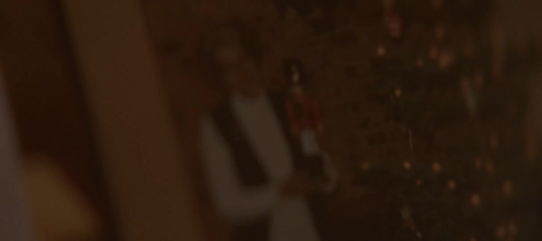 A close-up shot focuses on a faded, nostalgic photograph of a woman holding a nutcracker at Christmastime