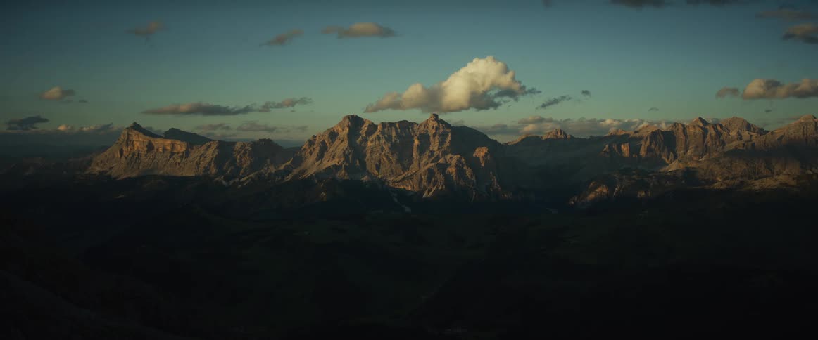 A breathtaking timelapse captures the sun setting over a vast mountain range as the landscape slowly fades into darkness