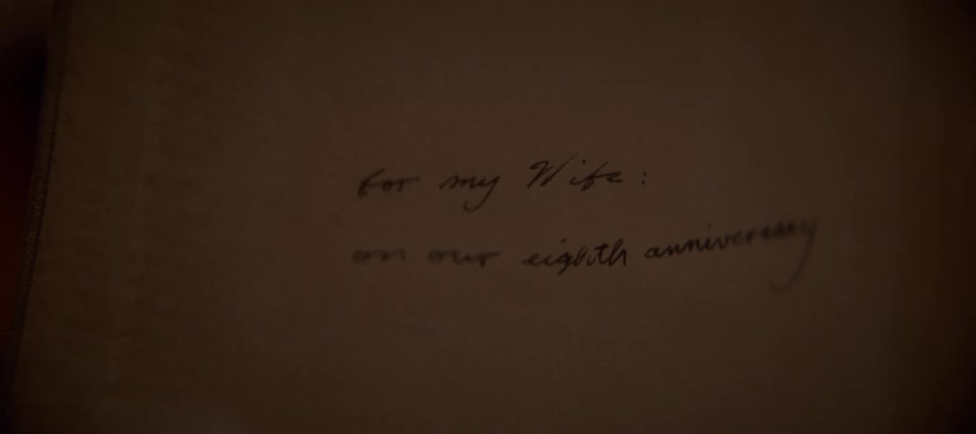 A soft-focus, intimate shot of a handwritten note reading "for my Wife: on our eighth anniversary" on vintage-style paper