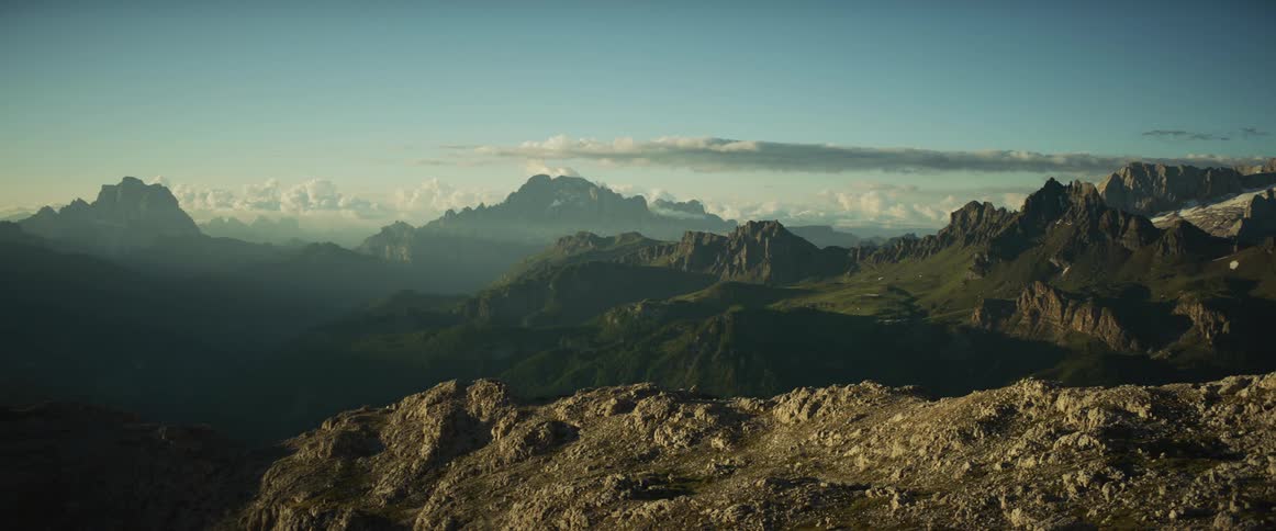 A stunning timelapse captures the sunrise over a vast mountain range, with light slowly spilling into the valleys and illuminating the landscape