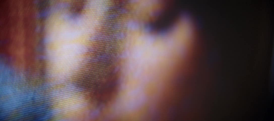 An abstract macro dolly shot of a person's face on a digital screen revealing the individual pixels