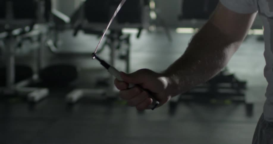 A man is jumping rope in a gym