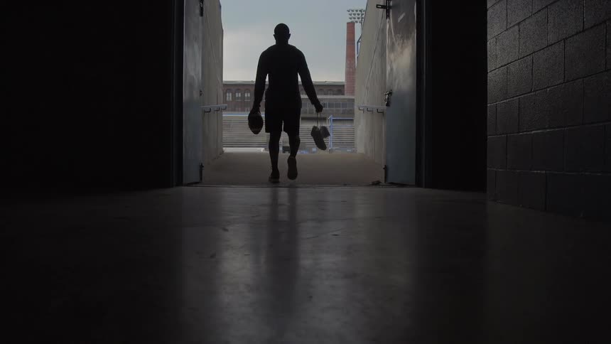 Sports player walks through a long corridor