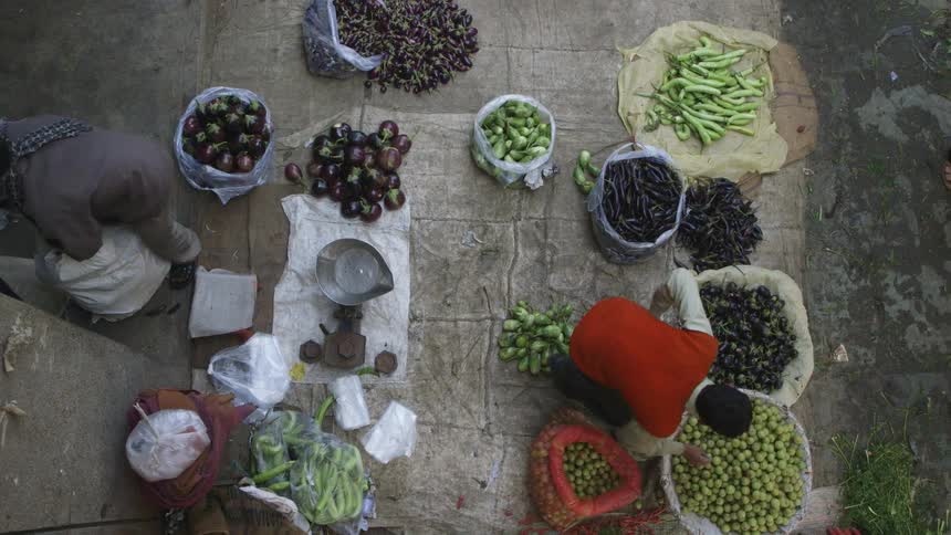 Several different types of food are in piles at a market